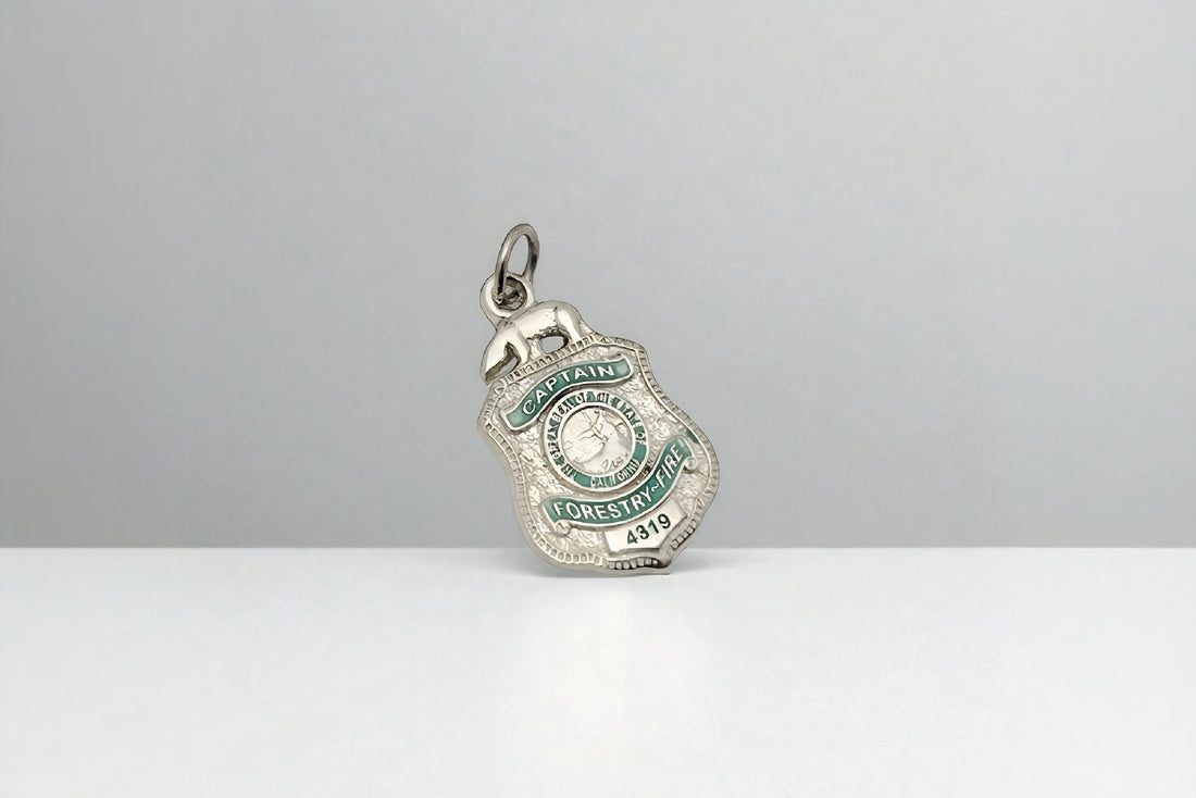 Silver Captain Forestry Fire badge pendant with green enamel details and number 4319, symbolizing law enforcement and firefighter service