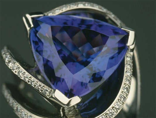 Close-up of a stunning tanzanite gemstone set in a silver ring with diamond accents.