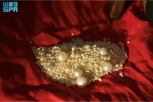 A collection of white pearls scattered on a red cloth.