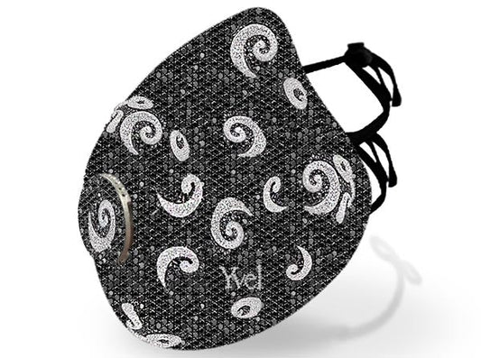 Close-up of a stylish black face mask adorned with swirling silver rhinestones. The mask features a sleek, modern design with adjustable straps and is branded with the logo 'Yvel.