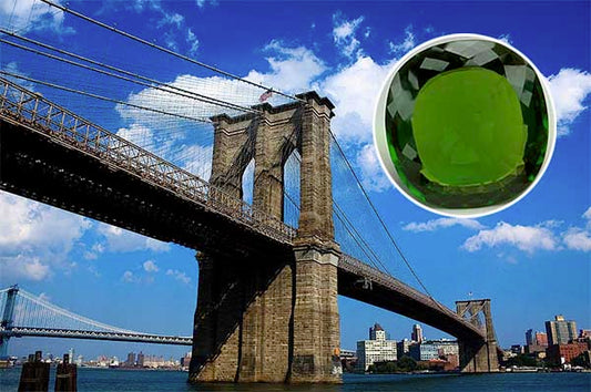 Brooklyn Bridge with the New York skyline in the background under a sunny sky, with an inset image of a vibrant green emerald gemstone, showcasing both the iconic landmark and precious stone.