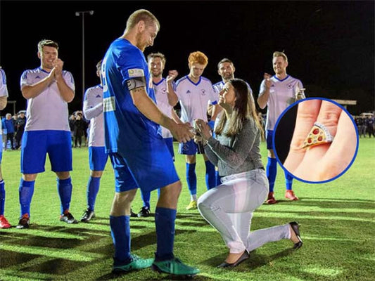 A footballer kneels on the field to propose to his partner while surrounded by teammates, with a close-up of the unique pizza slice engagement ring.