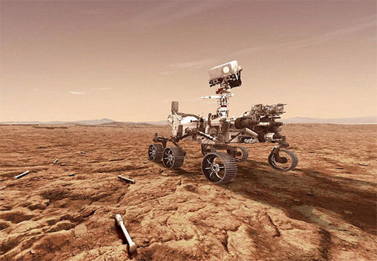 NASA's Mars rover exploring the Martian surface, with dusty terrain and distant mountains in the background.