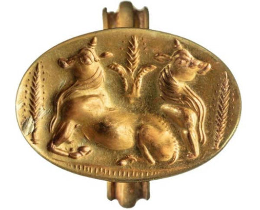 Ancient gold seal featuring a detailed relief of two cows, symbolizing agriculture or livestock, with foliage design around them.