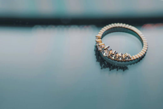 Close-up of a diamond-studded gold ring with a unique, elegant design.
