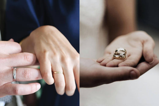Close-up of a couple exchanging wedding rings, one person wearing a wedding band and the other holding a pair of gold rings.