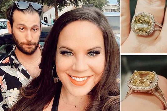 Couple posing for a selfie with a close-up of the woman's engagement ring featuring a large yellow cushion-cut diamond surrounded by smaller diamonds.
