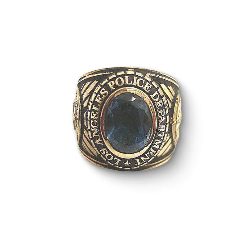 Close-up of a Los Angeles Police Department ring, featuring a blue gemstone at the center with engraved lettering around the band.