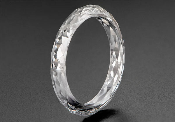 Clear, sparkling diamond ring with intricate facets, showcasing its brilliance and round shape.