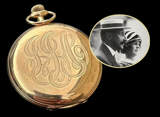 Gold pocket watch with intricate engraving and a vintage photo of a couple, featuring a monogram 'H' design.
