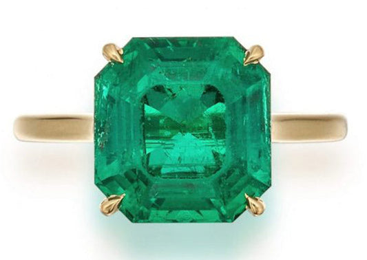 Emerald gemstone ring with a large rectangular cut, set in yellow gold, showcasing vibrant green hues and clear clarity.