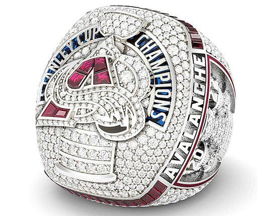 2022 Stanley Cup Championship ring featuring the Colorado Avalanche logo, adorned with diamonds and red gemstones, with 'Avalanche' and 'Champions' inscribed.