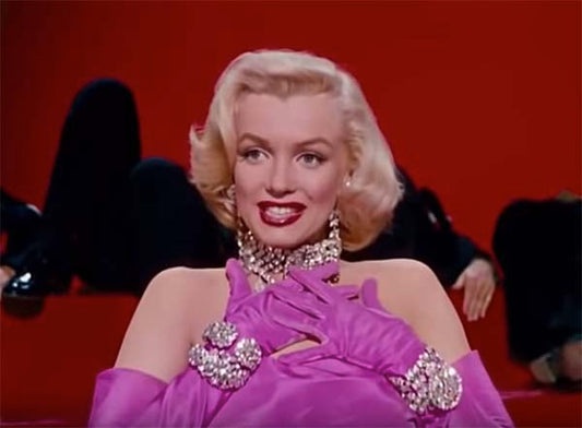 Marilyn Monroe wearing glamorous pink gloves and sparkling jewelry, performing on stage with a striking red background, iconic look from 'Gentlemen Prefer Blondes.