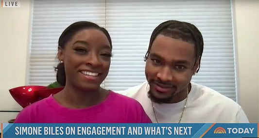 Simone Biles and her fiancé posing for an interview on the Today Show, smiling and seated together. The image captures their joyful moment with a banner reading 'Simone Biles on Engagement and What’s Next' at the bottom.