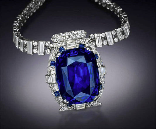 Luxurious sapphire necklace with diamonds and blue gemstones, featuring a large center sapphire surrounded by a diamond-encrusted chain.