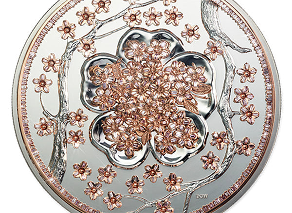 Silver coin with intricate design of cherry blossom flowers and branches, featuring rose gold accents.