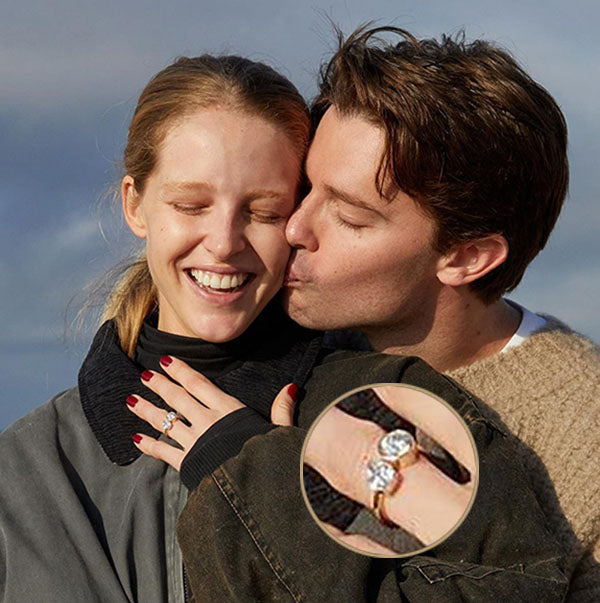 Happy couple sharing a kiss, with the woman showcasing her engagement ring featuring a diamond, with a close-up of the ring inset.