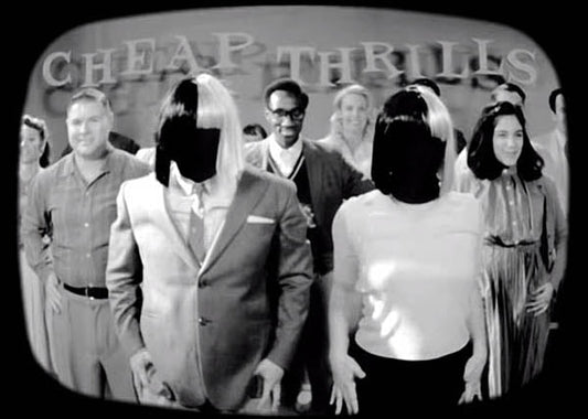 Black and white photo of a group of people with inverted wigs, dancing and smiling in front of a sign that reads 'Cheap Thrills.