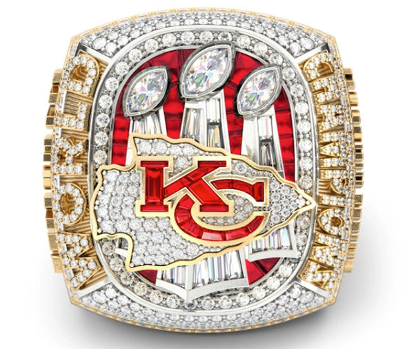 Close-up of the Kansas City Chiefs Super Bowl championship ring with diamonds and red accents, showcasing three trophies and the team logo.