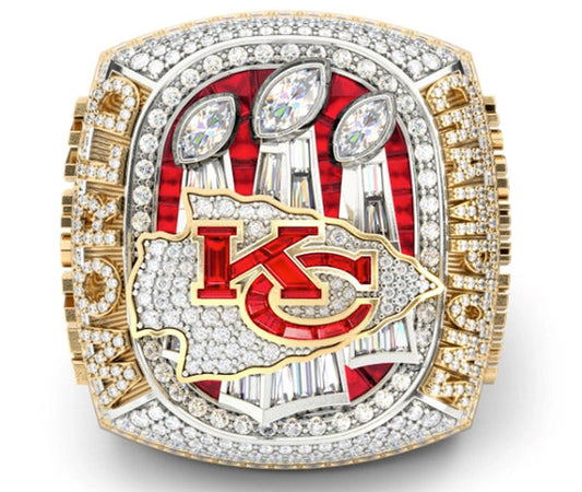 Close-up of the Kansas City Chiefs Super Bowl championship ring with diamonds and red accents, showcasing three trophies and the team logo.