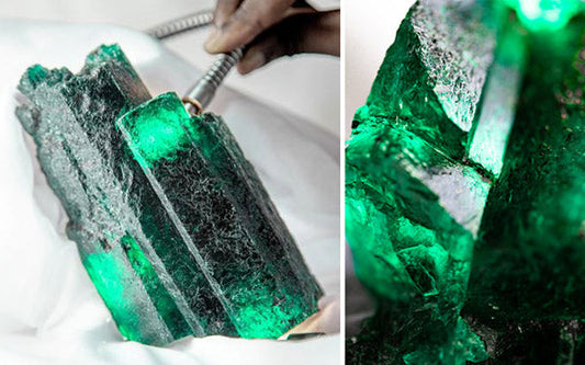 Large, rough emerald crystal being cleaned, glowing with vibrant green hues, showcasing its raw and natural beauty in a close-up shot.