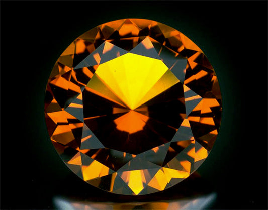 Orange-yellow gemstone with brilliant cut, showcasing vibrant light reflections and deep facets.
