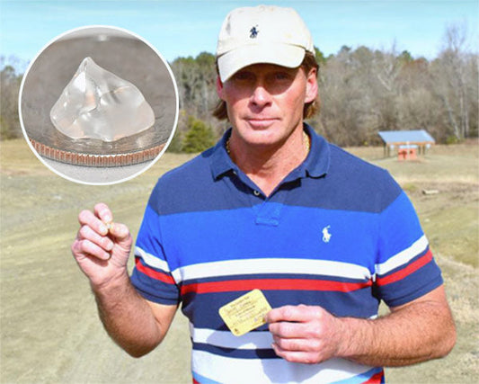 Man holding a clear diamond-like crystal he discovered, with an inset showing the crystal next to a coin for size comparison.