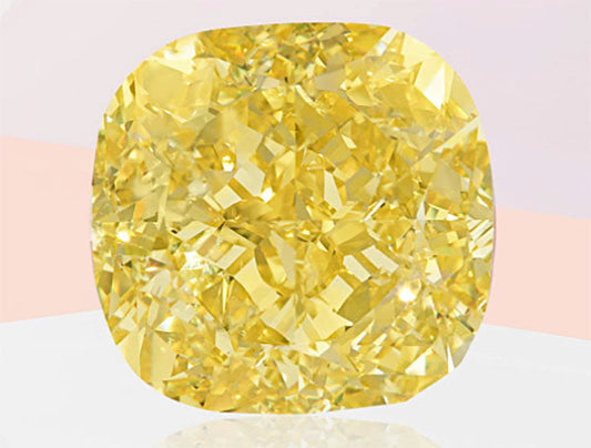 Large cushion-cut yellow diamond with brilliant facets, reflecting light, set against a soft gradient background.