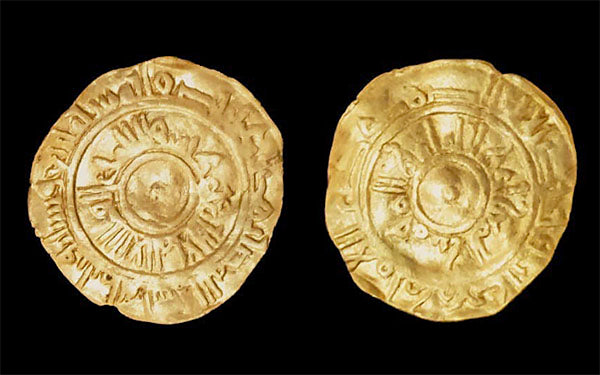 Ancient gold coin featuring intricate inscriptions and a sunburst design on both sides, dating back to historical times.