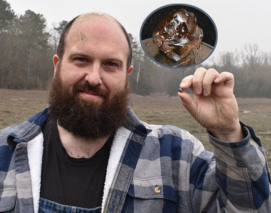 Man with a beard smiling and holding a rough diamond he just found, with an inset showing a close-up of the gemstone.