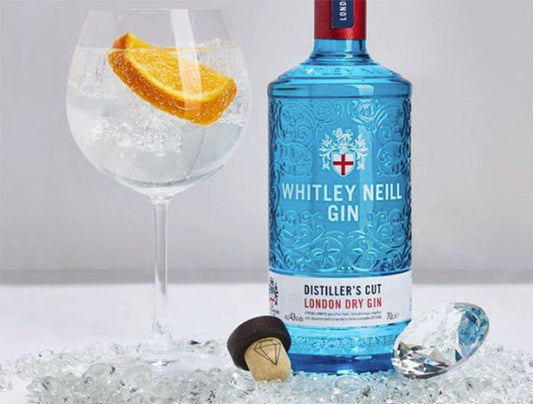 Whitley Neill Distiller's Cut London Dry Gin bottle with a glass of gin and ice, garnished with an orange slice, placed on crushed ice with a diamond and cork.