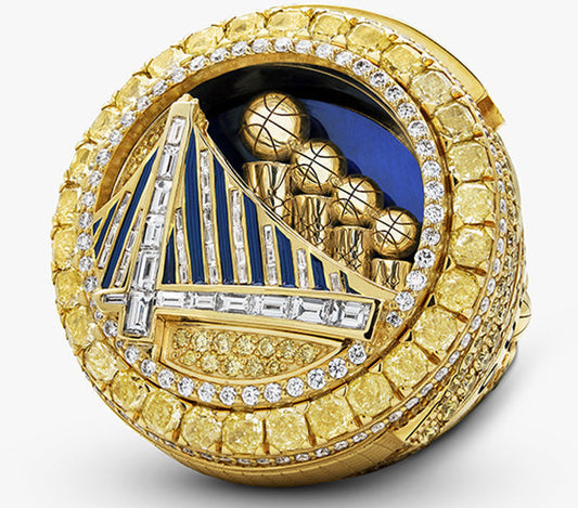 Golden NBA Championship ring featuring a diamond-encrusted design, with a bridge logo, basketballs, and a mix of yellow and white diamonds.