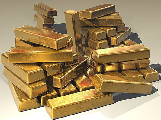 A pile of shiny gold bars stacked haphazardly, showing varying sizes and angles, symbolizing wealth and prosperity.