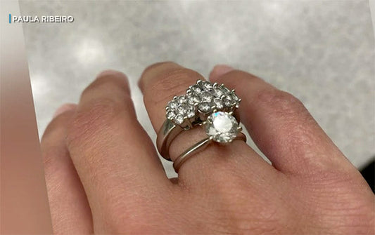 Close-up of a hand wearing two elegant silver rings, one with a cluster of diamonds and the other with a single large diamond at the center.