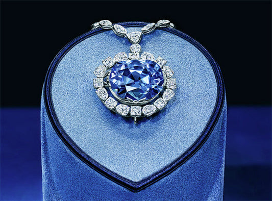 The Hope Diamond, a large blue diamond surrounded by smaller white diamonds, displayed on a velvet stand.