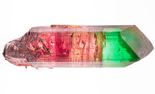 Close-up image of a colorful tourmaline crystal, displaying vibrant hues of pink, red, and green with a smooth, pointed end.