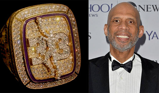 Kareem Abdul-Jabbar smiling at an event, wearing a tuxedo, with a close-up of his retired NBA jersey ring featuring diamonds and the number '33'.