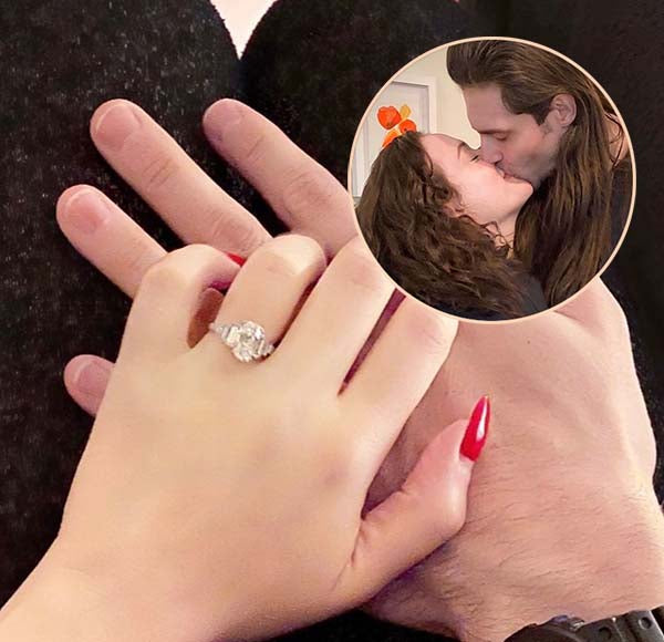 Engagement ring featuring a large diamond on a hand, with a close-up of the couple kissing in the inset photo.
