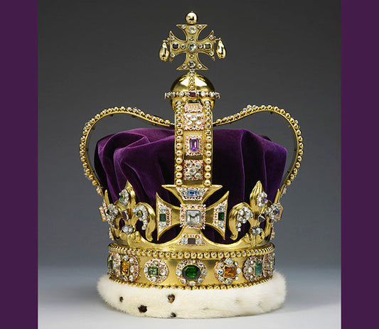Golden royal crown with purple velvet lining, adorned with diamonds, emeralds, and other colorful gemstones, featuring a cross at the top and a fur trim at the base.