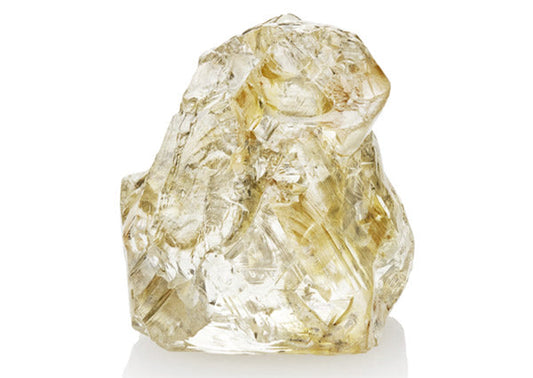 Rough yellow diamond crystal with natural facets on a white background.