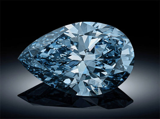 Close-up of a large, flawless blue diamond with a pear shape, showcasing exceptional clarity and brilliance against a black background.
