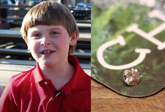 A young boy smiling next to a close-up of a diamond resting on a 'CH' branded paper, symbolizing the discovery of a precious gem.
