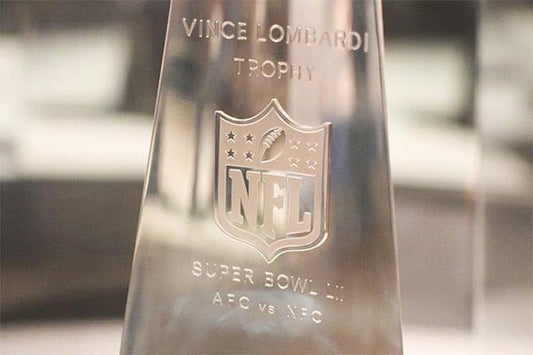 Close-up of the Vince Lombardi Trophy, engraved with the NFL logo and 'Super Bowl LI' inscription. The trophy is displayed with a clear view of its design and intricate details.