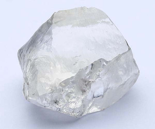 Uncut rough diamond with clear, translucent appearance and natural facets, showcasing its raw form before processing.