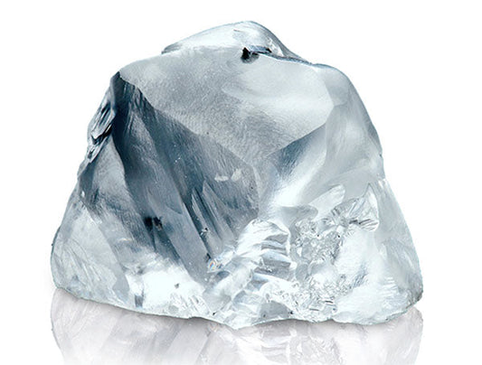 Close-up of a rough, uncut diamond with clear, transparent facets.