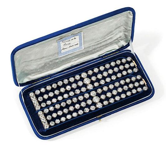 Luxury diamond bracelet set displayed in a blue velvet box, featuring multiple sparkling diamonds.