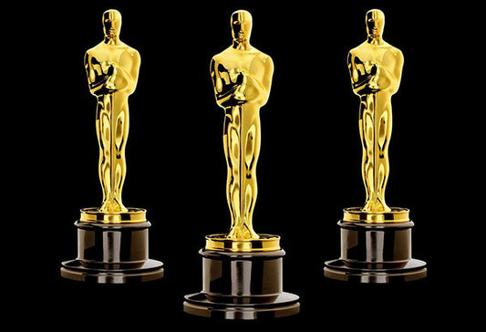 Three golden Oscar statuettes, each mounted on a black base, symbolizing awards for excellence in film.