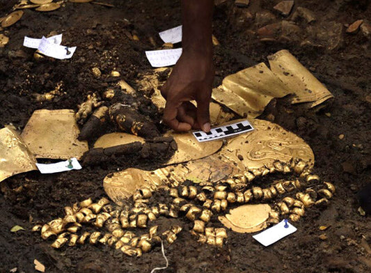  Archaeological excavation of a treasure trove, with gold coins, jewelry, and other artifacts being carefully examined and cataloged.