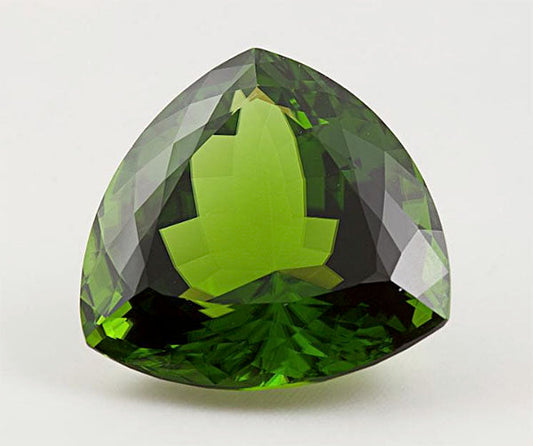 Large, triangular green gemstone with vivid green and dark tones, highlighting its unique cut and clarity.