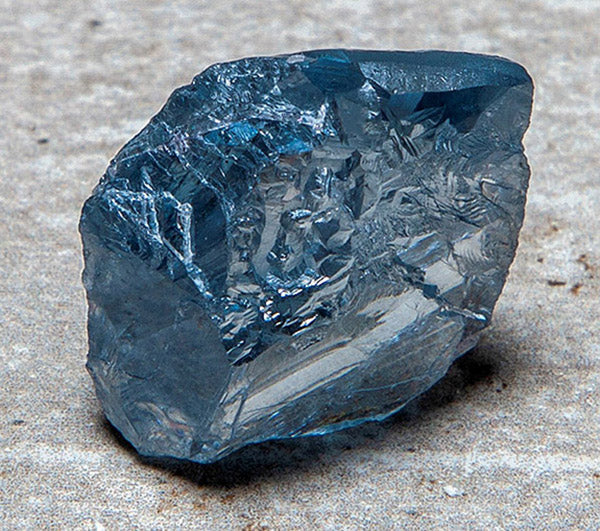Close-up of a raw blue diamond crystal showing its unique clarity, angular edges, and light blue hue.